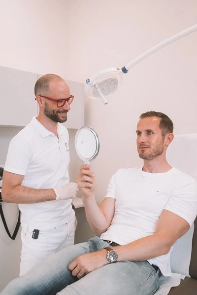 Dr. Gábor Bali bespricht mit einem Patienten das Ergebnis einer ästhetischen Behandlung